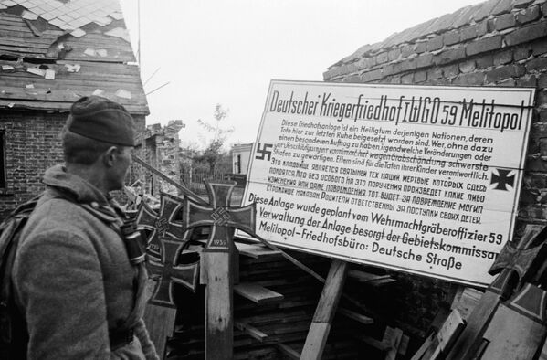 A Soviet soldier reads a notice posted by the Germans, which says: “This cemetery is a shrine of those nations whose dead rest here. Whoever makes any changes or even damages the graves without special instructions will be strictly punished for damaging them. Parents are responsible for the deeds of their children.” - Sputnik International