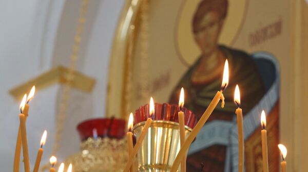 Candles are lit during a service at the Holy Transfiguration Church, in Volnovakha, Donetsk People's Republic, Russia - Sputnik International