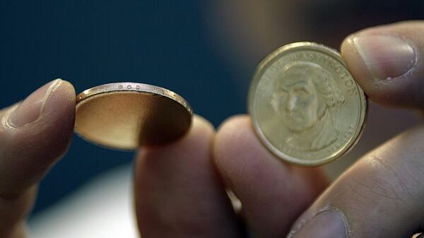 One of a group of the misstruck new presidential dollar coins, left, that has the In God We Trust lettering stamped on the edge, but showing no presidential face, is displayed next to a new presidential dollar showing President George Washington, right, at the Professional Coin Grading Service offices in Santa Ana, Calif., Tuesday, March 13, 2007. - Sputnik International