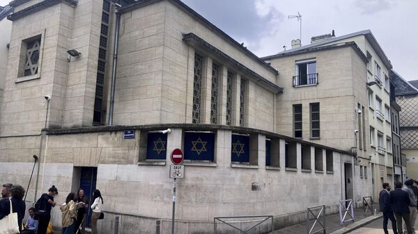 People stand in front the synagogue in Rouen after a man armed with a knife and a metal bar is suspected of having set fire, Friday, May 17, 2024 - Sputnik International