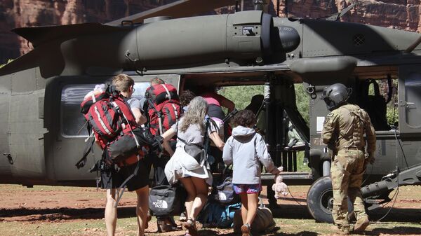 U.S. Army soldiers of the Arizona National Guard guide tourists trapped by flash flooding into a UH-60 Blackhawk, Saturday, Aug. 24, 2024, on the Havasupai Reservation in Supai, Ariz.  - Sputnik International