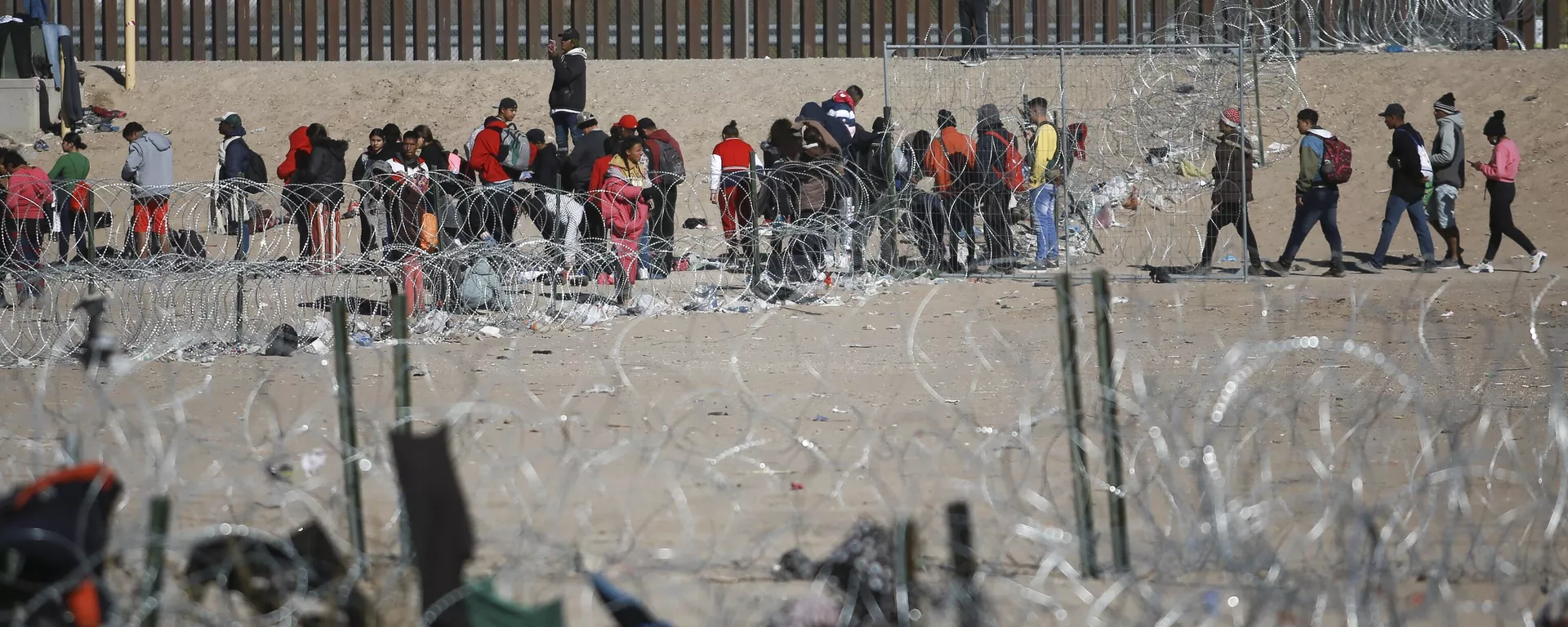 Migrants line up at the U.S. border wall after being detained by U.S. immigration authorities, seen from Ciudad Juarez, Mexico, Wednesday, Dec. 27, 2023. - Sputnik International, 1920, 25.11.2024