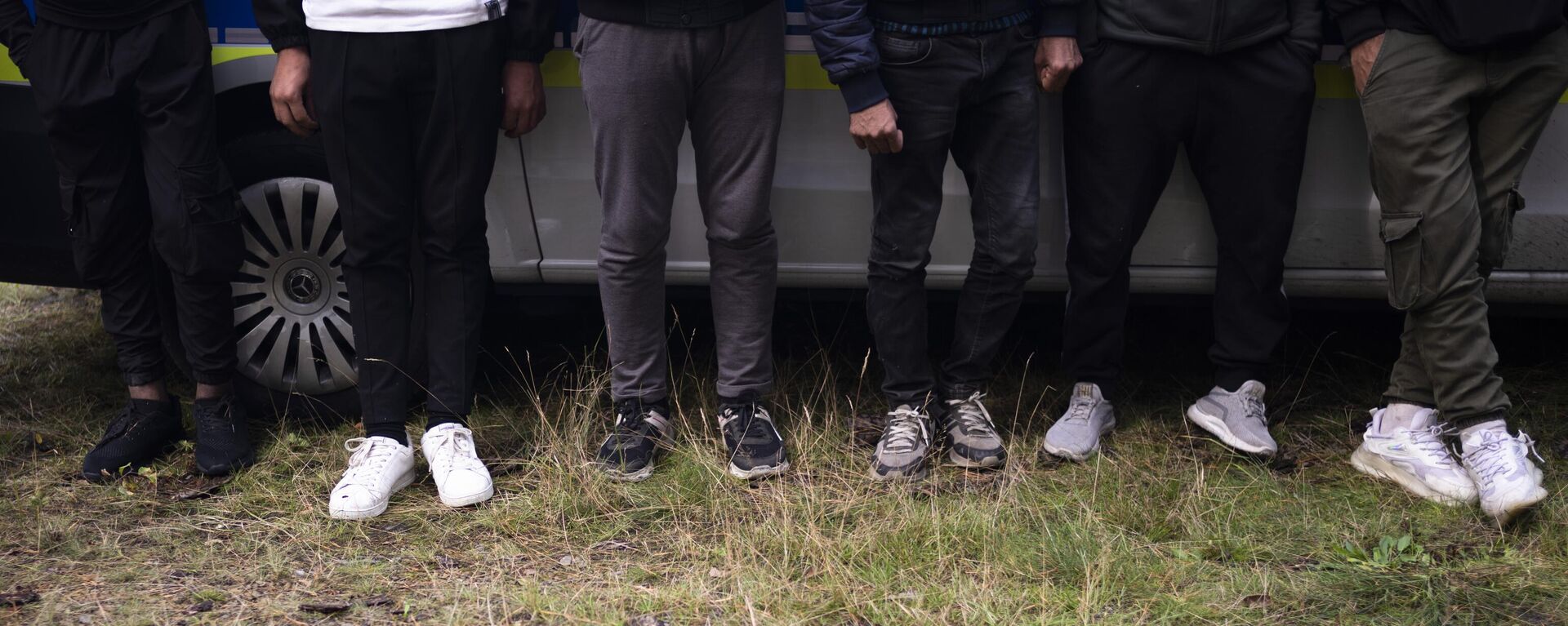 Migrants wait at a police car after they illegally crossed the border from Poland into Germany and tracked down from a Federal Police patrol in a forest near Forst southeast of Berlin, Germany, Wednesday, Oct. 11, 2023 - Sputnik International, 1920, 27.08.2024