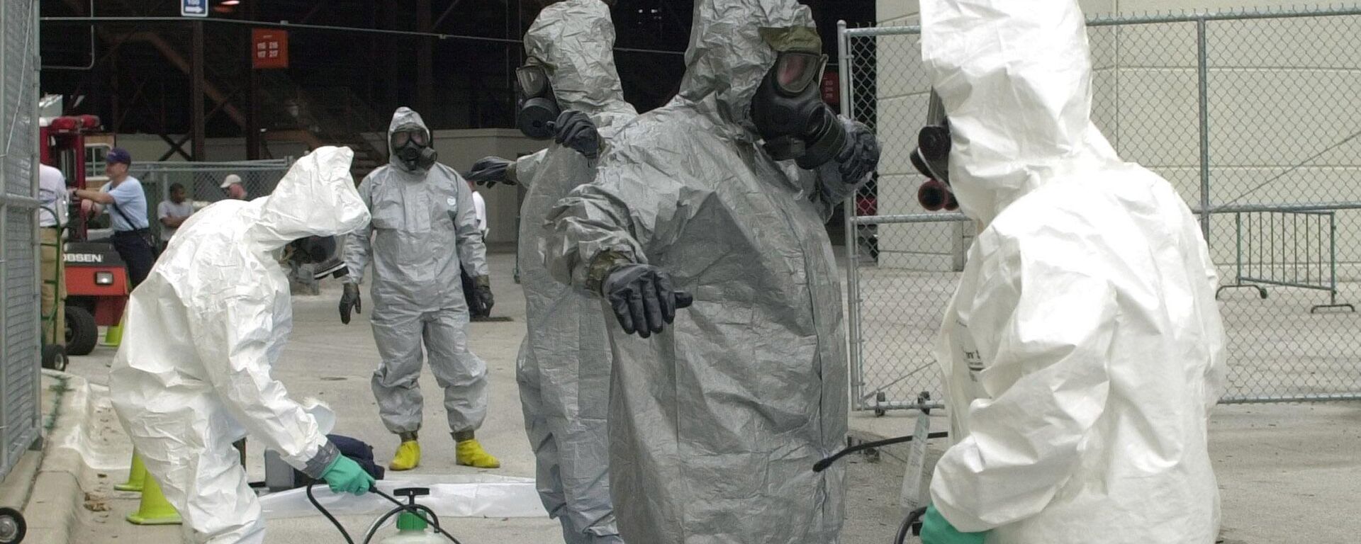 Members of the U.S. Army Technical Escort Unit Chemical/Biological Team, in gray HAZMAT suits, are decontaminated by Orlando firefighters, in white HAZMAT suits, at the Citrus Bowl in Orlando, Fla., Tuesday, May 14, 2002. The training exercise was called Sunshine Guardian.  - Sputnik International, 1920, 27.08.2024