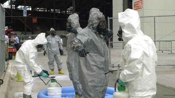 Members of the U.S. Army Technical Escort Unit Chemical/Biological Team, in gray HAZMAT suits, are decontaminated by Orlando firefighters, in white HAZMAT suits, at the Citrus Bowl in Orlando, Fla., Tuesday, May 14, 2002. The training exercise was called Sunshine Guardian.  - Sputnik International