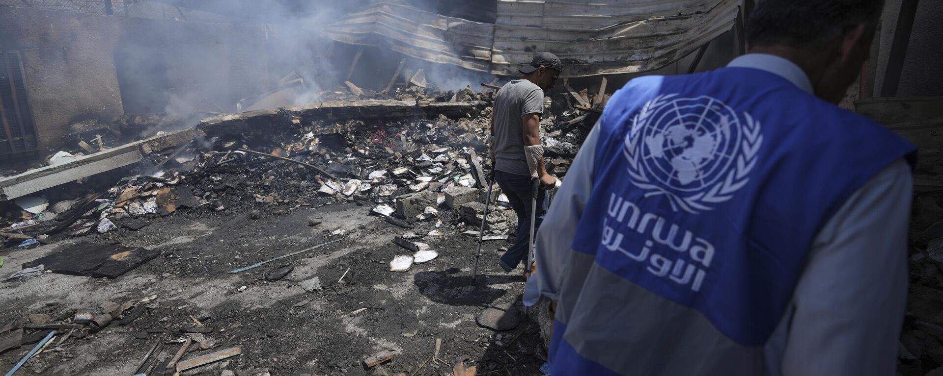 Palestinians look at the destruction after an Israeli strike on a school run by UNRWA, the U.N. agency helping Palestinian refugees, in Nuseirat, Gaza Strip, May 14, 2024. Qatar and Saudi Arabia on Sunday, June 2, 2024 condemned an Israeli parliamentary bill that seeks to label UNRWA, the main provider of aid for Palestinians in Gaza, a terrorist group, joining a growing number of nations opposed to the proposal - Sputnik International, 1920, 02.09.2024