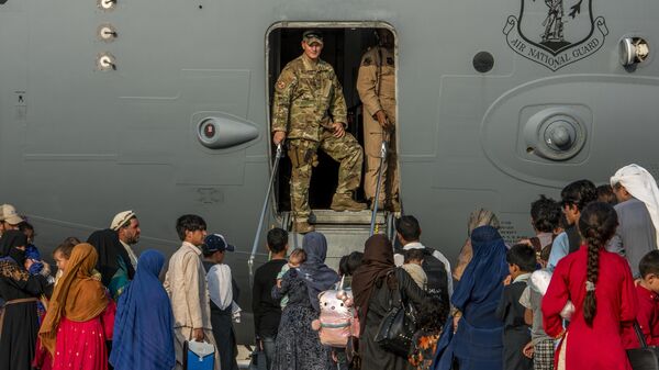 In this Aug. 22, 20121, image provided by the US Air Force, service members prepare to board evacuees onto a C-17 Globemaster lll on Sunday, Aug. 22, 2021, at Al Udeid Air Base, Qatar - Sputnik International