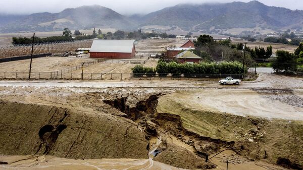 In this aerial image taken with a drone, a truck drives along River Rd. where heavy rains have caused mudslides and flooding near Salinas in Monterey County, Calif., on Thursday, Jan. 28, 2021 - Sputnik International