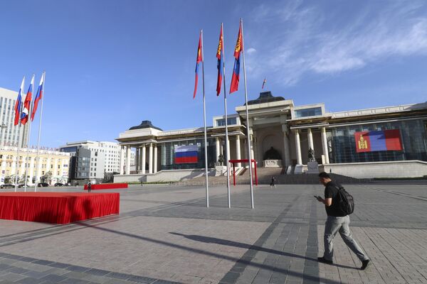 A man walks past Sukhbaatar Square, decorated with the national flags of Mongolia and Russia. - Sputnik International