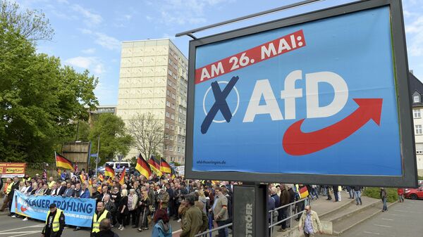 File picture taken May 1, 2019 shows AfD supporters walkin along a party elections poster in Erfurt, Germany. German media outlets are reporting the country's domestic intelligence agency has put the opposition Alternative for Germany party under observation under suspicion of extreme right sympathies - Sputnik International