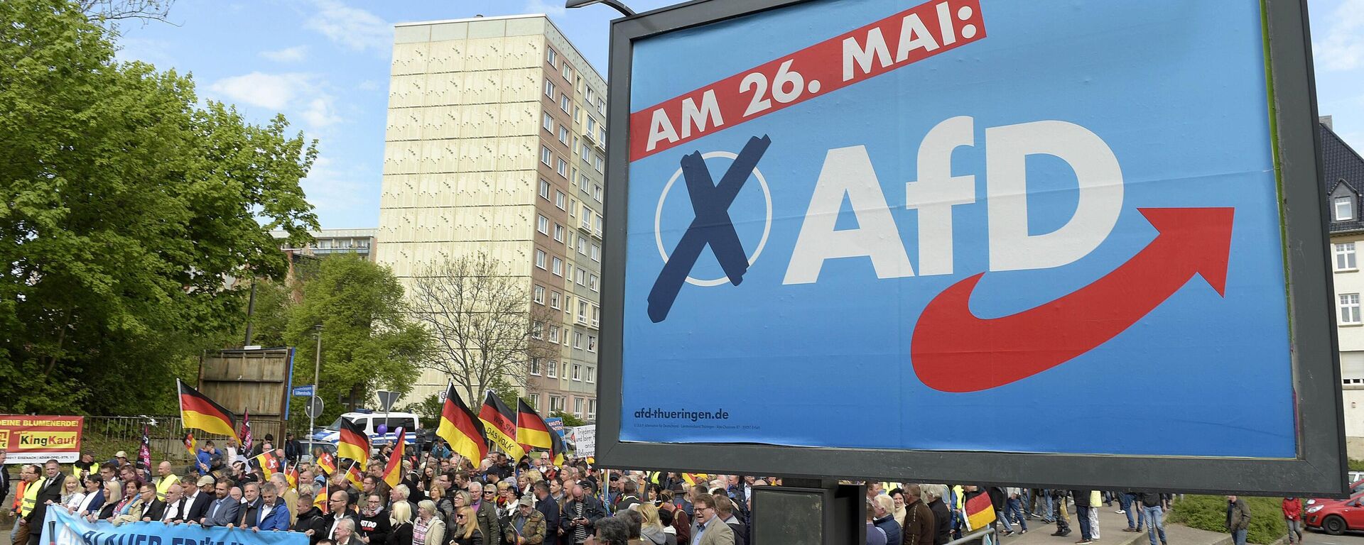 File picture taken May 1, 2019 shows AfD supporters walkin along a party elections poster in Erfurt, Germany. German media outlets are reporting the country's domestic intelligence agency has put the opposition Alternative for Germany party under observation under suspicion of extreme right sympathies - Sputnik International, 1920, 04.09.2024