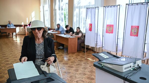 A woman votes at polling station No. 104 in Kursk. - Sputnik International