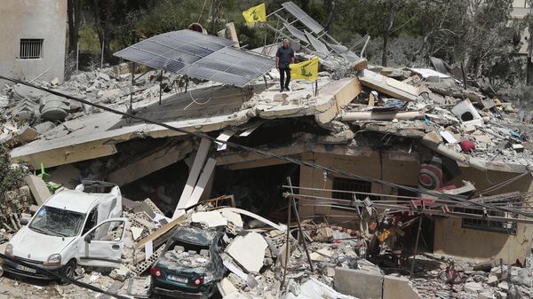 A man stands on a house that was destroyed by an Israeli airstrike, in Hanine village, south Lebanon, Thursday, April 25, 2024 - Sputnik International