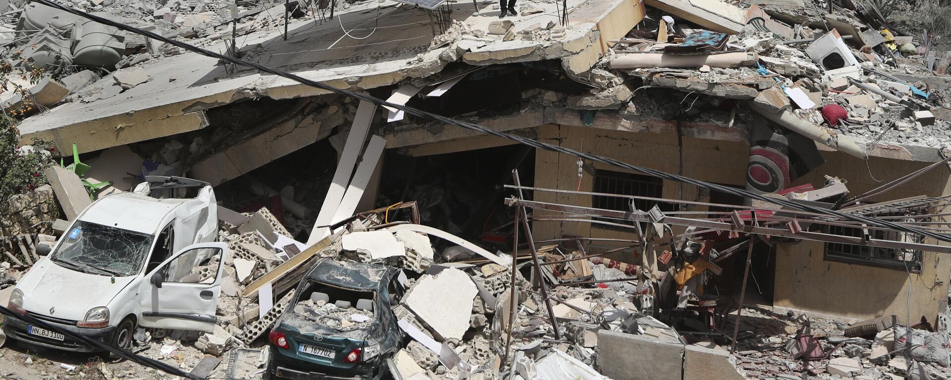 A man stands on a house that was destroyed by an Israeli airstrike, in Hanine village, south Lebanon, Thursday, April 25, 2024 - Sputnik International, 1920, 13.09.2024