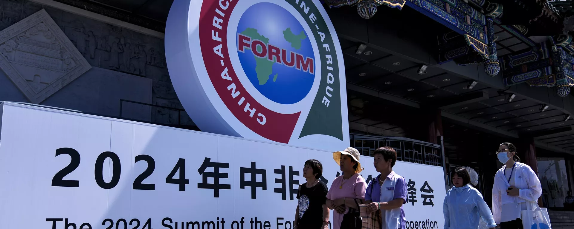 People walk past the display board of China-Africa Forum outside a trade market complex in Beijing, Monday, Sept. 2, 2024 - Sputnik International, 1920, 14.09.2024