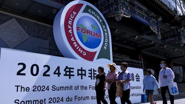 People walk past the display board of China-Africa Forum outside a trade market complex in Beijing, Monday, Sept. 2, 2024 - Sputnik International