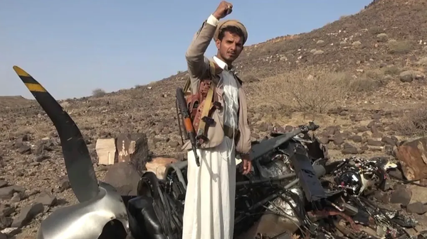 Houthi fighter poses in front of wreckage of US military MQ-9 Reaper drone shot down over Yemen. File photo. - Sputnik International