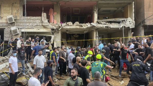 People gather near a damaged building at the scene of an Israeli missile strike in the southern suburbs of Beirut - Sputnik International