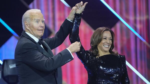 President Joe Biden, left, holds up the arm of Democratic presidential nominee Vice President Kamala Harris, right, while on stage at the Congressional Black Caucus Foundation's Phoenix Awards Dinner in Washington, Saturday, Sept. 14, 2024.  - Sputnik International