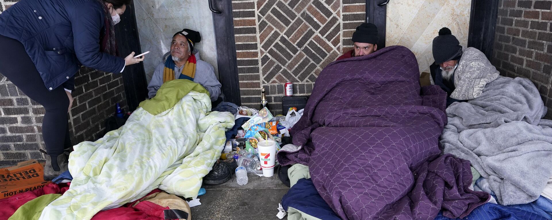 Morgan Handley, left, tries to convince people to come to move to a warming shelter to escape sub-freezing temperatures, Tuesday, Feb. 16, 2021, in San Antonio - Sputnik International, 1920, 22.09.2024