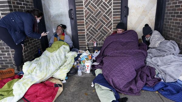 Morgan Handley, left, tries to convince people to come to move to a warming shelter to escape sub-freezing temperatures, Tuesday, Feb. 16, 2021, in San Antonio - Sputnik International