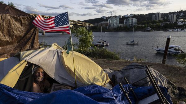 Frank, a homeless man, sits in his tent with a river view, June 5, 2021, in Portland, Ore, as homelessness nationwide has reached record highs. - Sputnik International