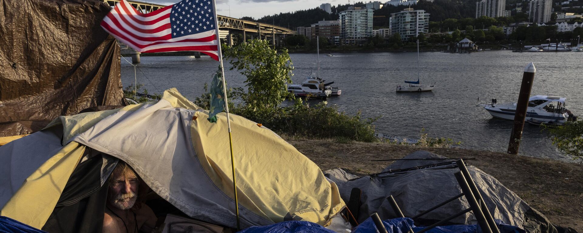 Frank, a homeless man, sits in his tent with a river view, June 5, 2021, in Portland, Ore, as homelessness nationwide has reached record highs. - Sputnik International, 1920, 28.10.2024