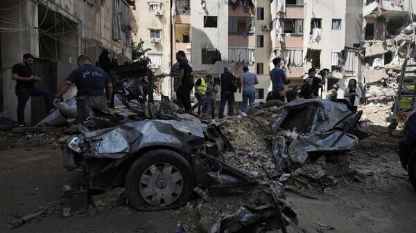 Emergency workers clear the rubble at the site of Friday's Israeli strike in Beirut's southern suburb, Sunday, Sept. 22, 2024. - Sputnik International