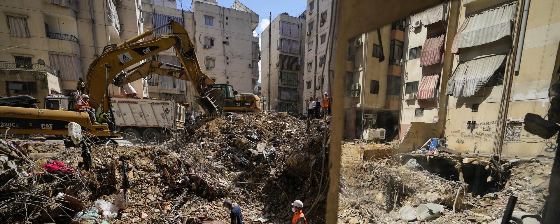 Emergency workers use excavators to clear the rubble at the site of Friday's Israeli strike in Beirut's southern suburbs, Lebanon, Monday, Sept. 23, 2024.  - Sputnik International, 1920, 25.09.2024