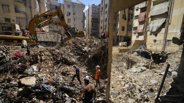 Emergency workers use excavators to clear the rubble at the site of Friday's Israeli strike in Beirut's southern suburbs, Lebanon, Monday, Sept. 23, 2024.  - Sputnik International