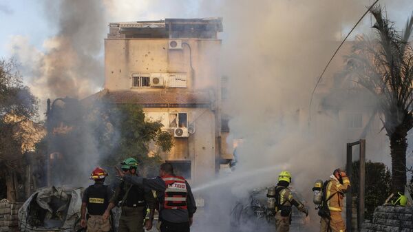 Israeli security and rescue forces work at the site hit by a rocket fired from Lebanon, in Kiryat Bialik, northern Israel, on Sunday, Sept. 22, 2024.  - Sputnik International