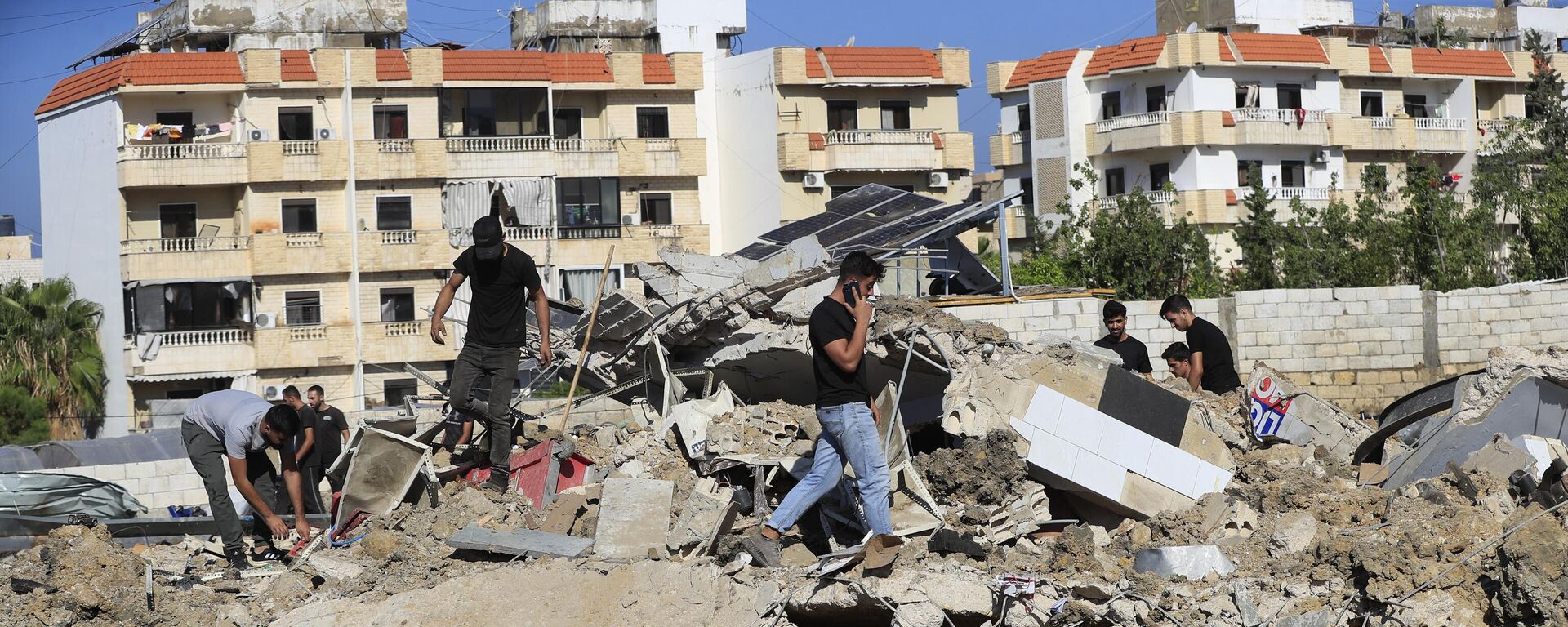 People gather at the site of an Israeli airstrike that hit a hangar in the southern town of Jiyeh, Lebanon, Wednesday, Sept. 25, 2024. - Sputnik International, 1920, 29.09.2024