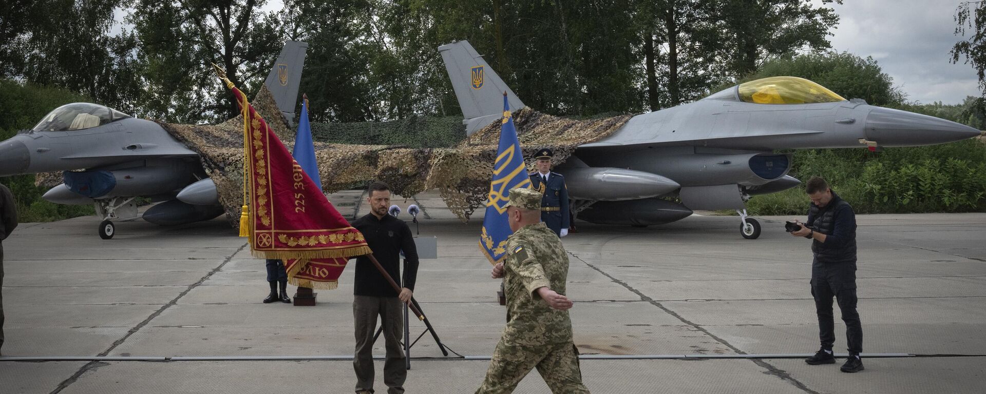 Volodymyr Zelenskyy hands over the flag of a military unit on the occasion of the Air Forces Day against the background of Ukraine's Air Force's F-16 fighter jets in an undisclosed location in Ukraine, Sunday, Aug. 4, 2024.  - Sputnik International, 1920, 27.09.2024