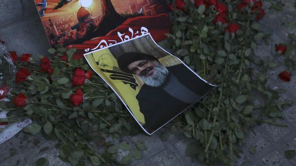 A poster of Hezbollah leader Sayyed Hassan Nasrallah is placed on flowers in front of the Lebanese Embassy in Tehran, Iran, Wednesday, Sept. 18, 2024. - Sputnik International