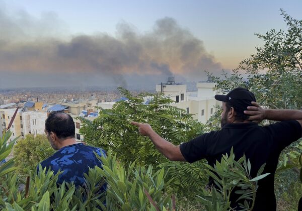 Lebanese people watch smoke rise from Israeli airstrikes. - Sputnik International