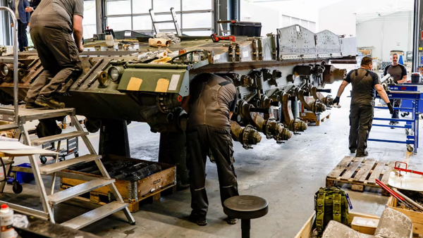 Screenshot showing technicians working on a vehicle at a Rheinmetall facility in Germany. - Sputnik International