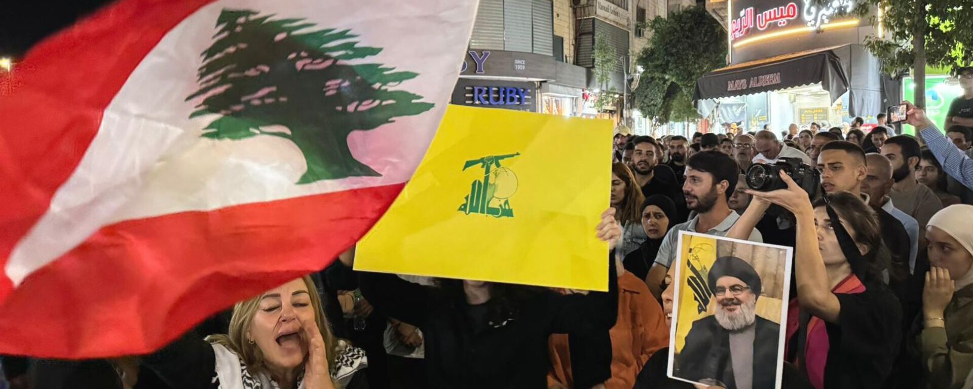 Palestinian protesters carry Lebanese flags, Hezbollah flags and posters with a picture of Hezbollah leader Sayyed Hassan Nasrallah during a rally in support of Hezbollah, in the West Bank city of Ramallah. - Sputnik International, 1920, 29.09.2024