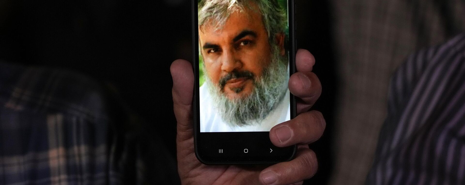 An Iranian demonstrator shows a portrait of Hezbollah leader Hassan Nasrallah on his cell phone, Sept. 28, 2024.  - Sputnik International, 1920, 30.09.2024