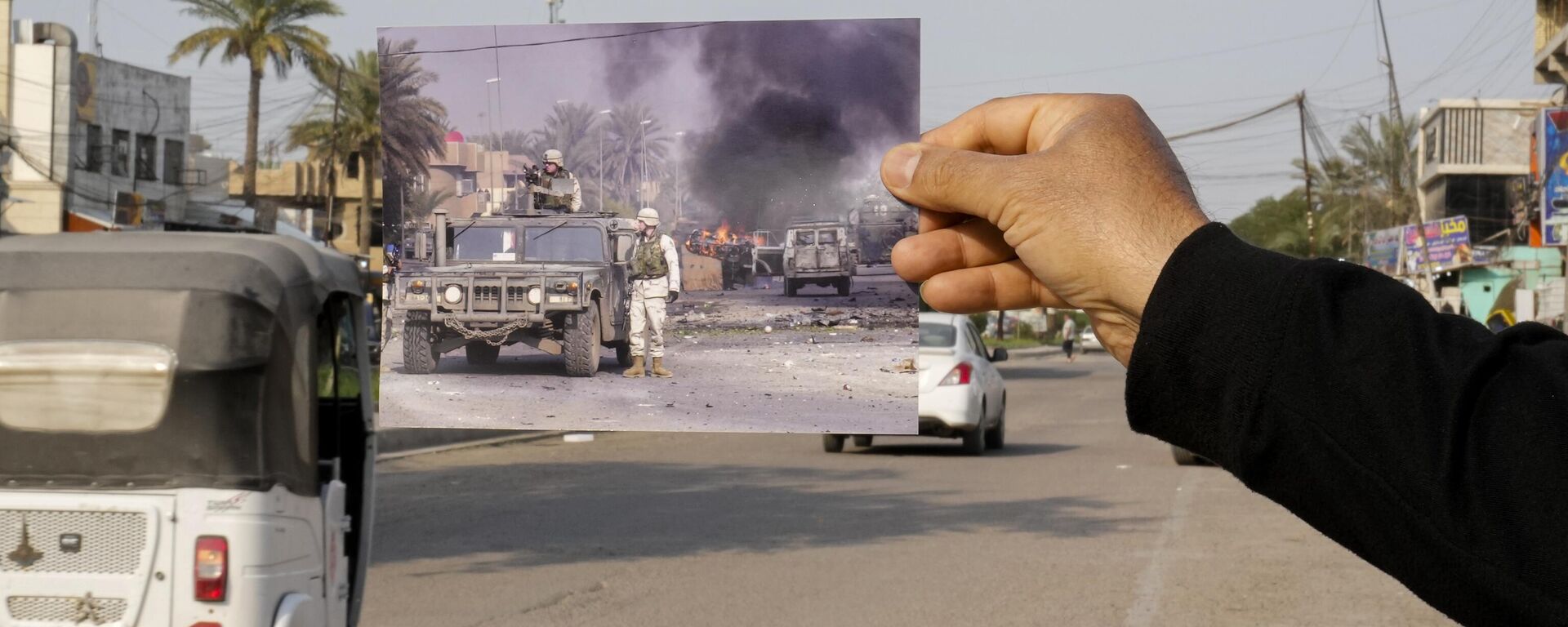 A photograph of U.S. troops securing the area after explosives went off in Baghdad's Palestine Street Wednesday, Dec. 31, 2003, is inserted into the scene at the same location Friday, March 24, 2023. 20 years after the U.S. led invasion on Iraq and subsequent war.  - Sputnik International, 1920, 02.03.2026