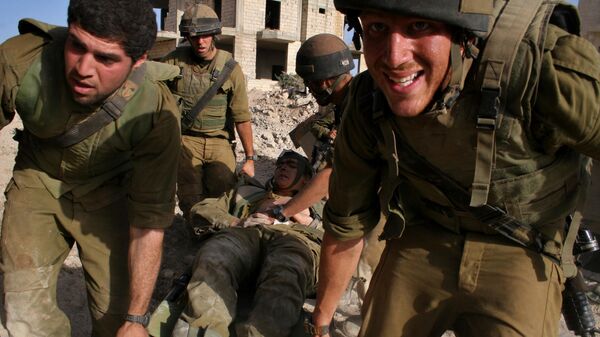 Israeli Army medic Tom Shechter is evacuated by colleagues after the unit came under attack from Hezbollah guerrillas with anti-tank missiles in the village of Inta, outskirts of the southern Lebanon town of  Bint Jbail  early Saturday Aug. 12, 2006.  The unit was clearing routes for armored vehicles and infantry. - Sputnik International