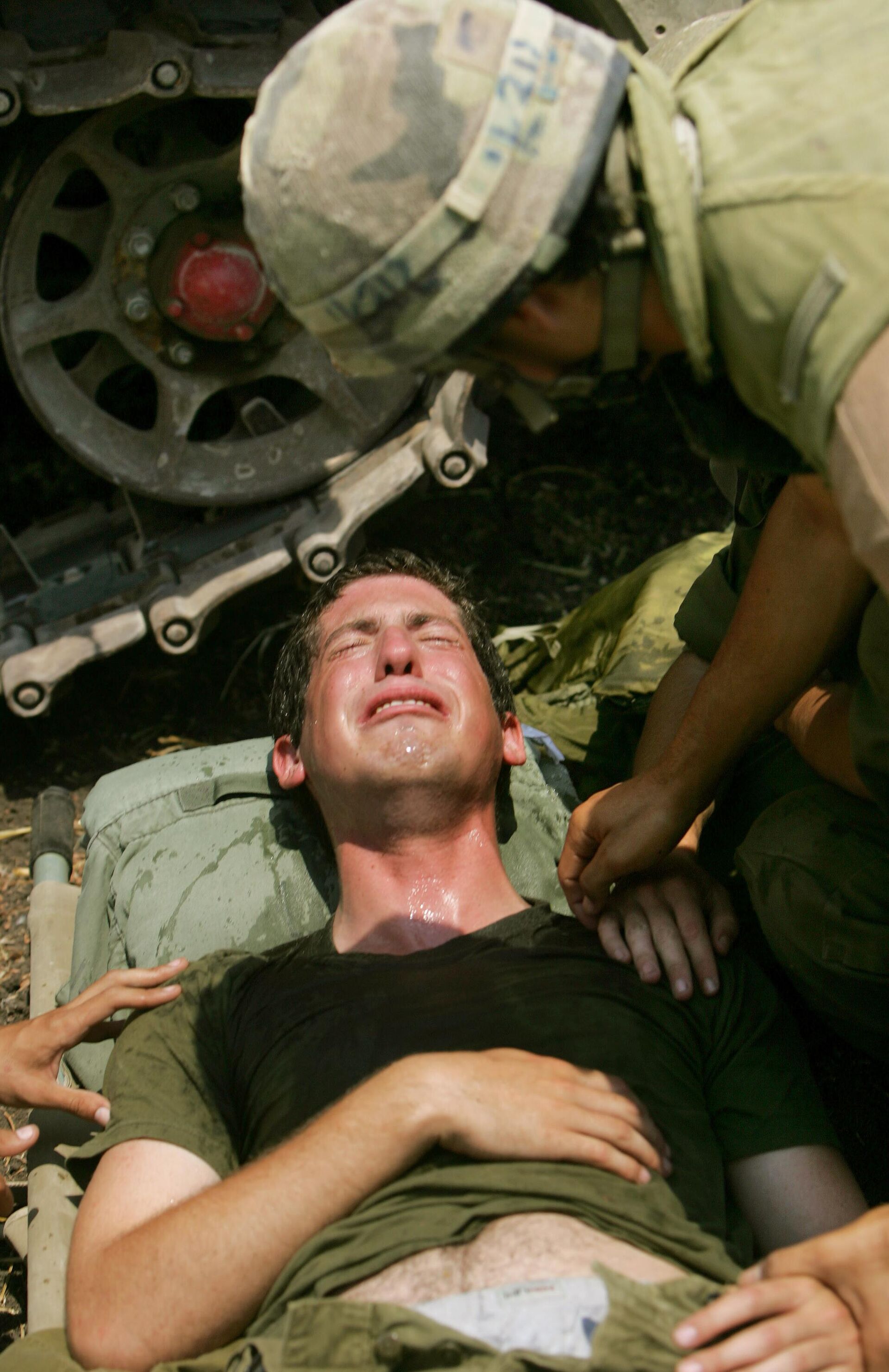 An Israeli soldier reacts after he was injured when a rocket fired by Hezbollah guerrillas hit the area at an Israeli artillery  position near the northern Israeli town of Kiryat Shmona ,Saturday, July 22, 2006.  - Sputnik International, 1920, 30.09.2024