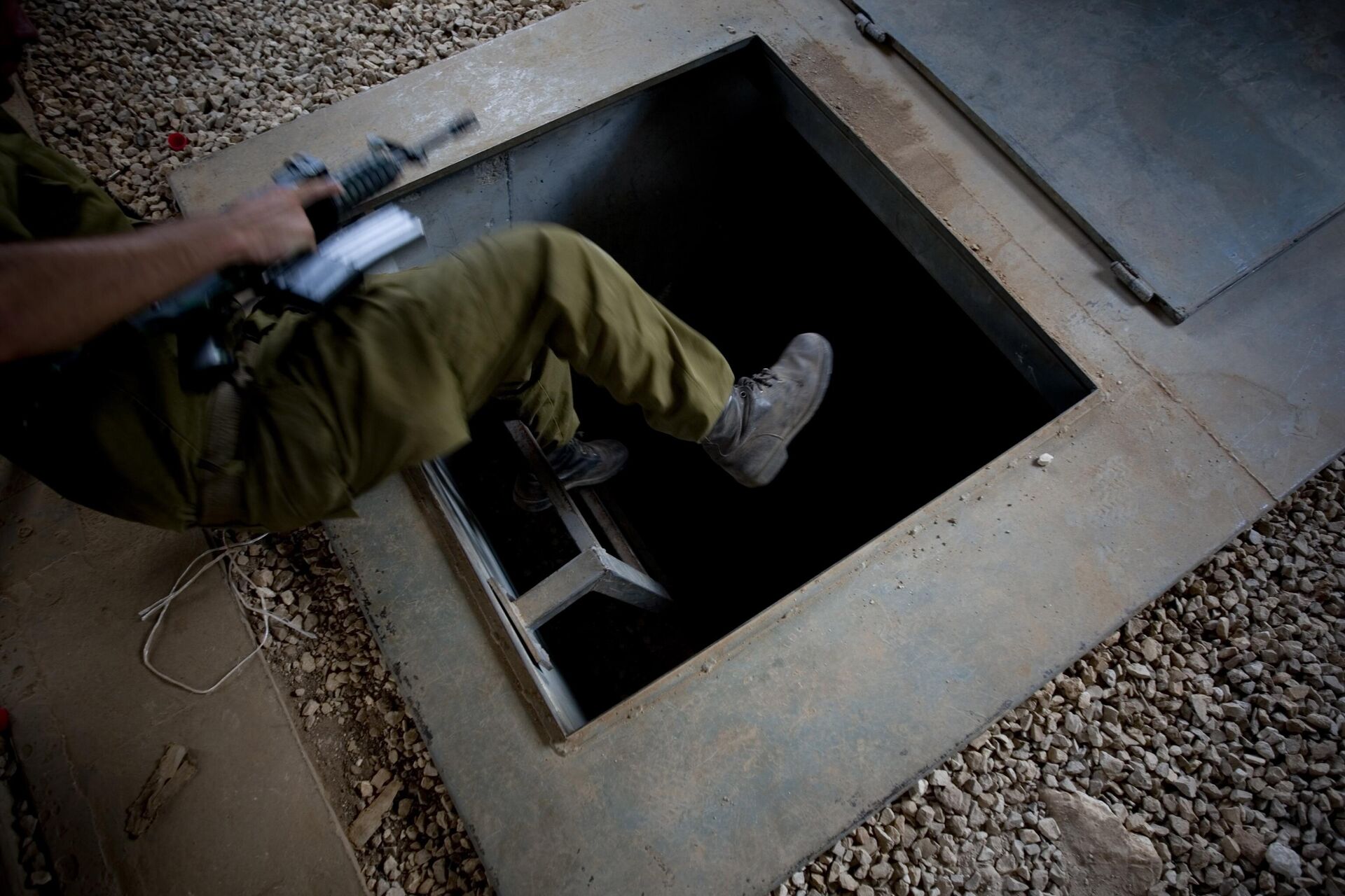 In this file photo taken Wednesday, July 21, 2010, an Israeli soldier jumps into a tunnel during training simulating military posts in south Lebanon, at the Elyakim training grounds, northern Israel.  - Sputnik International, 1920, 30.09.2024