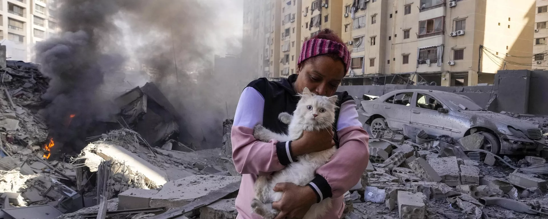 A woman holds her cat in front of a destroyed building at the site of an Israeli airstrike in Dahiyeh, Beirut, Lebanon - Sputnik International, 1920, 03.10.2024