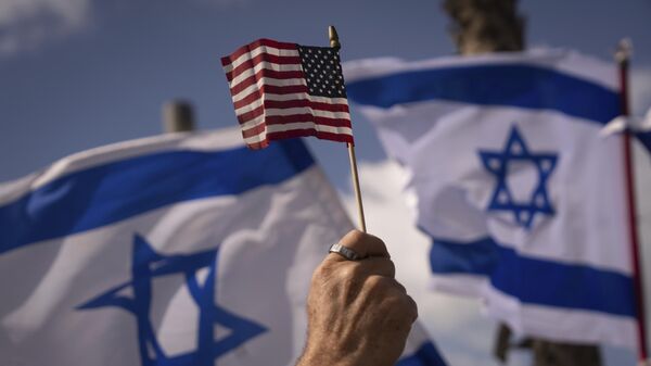 Israelis opposed to a contentious government plan to overhaul the judiciary wave Israeli and U.S. flags during a protest in support of U.S. President Joe Biden, who criticized the plan this week, outside of the U.S. Embassy Branch Office in Tel Aviv, Israel, Thursday, March 30, 2023 - Sputnik International