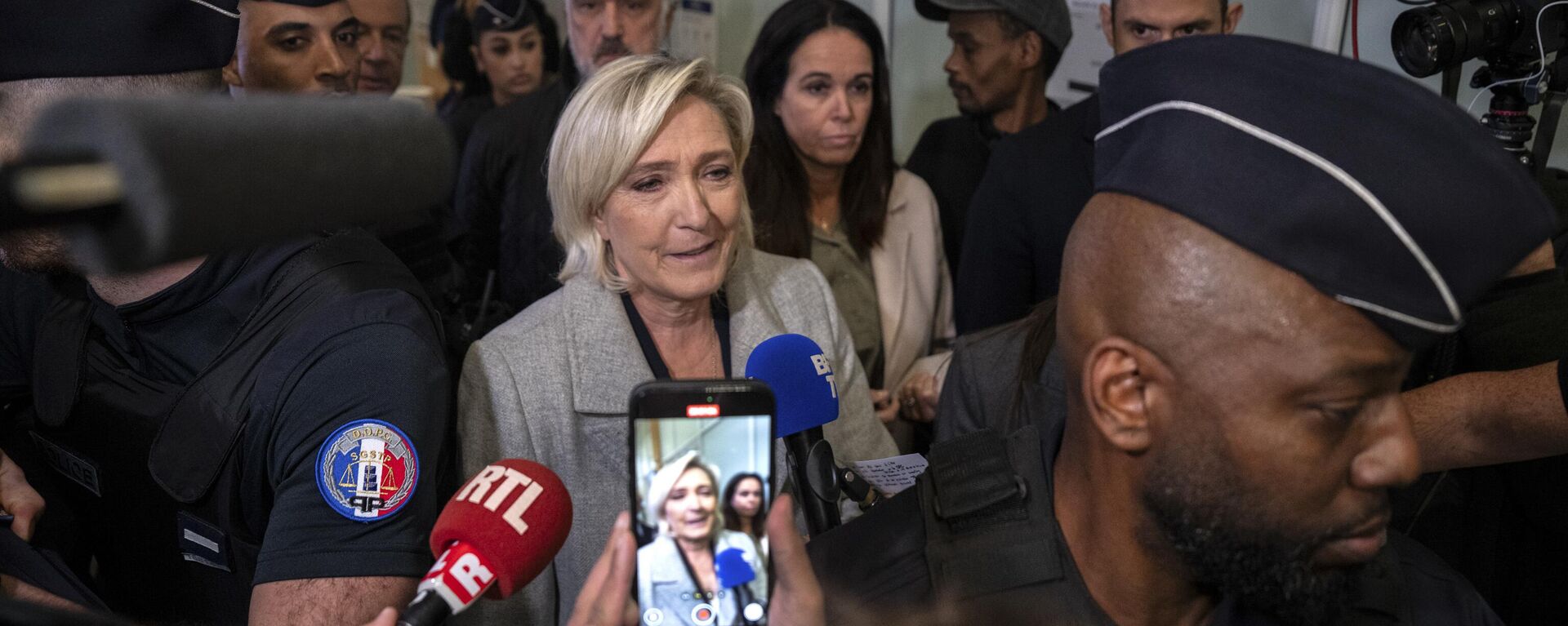 French populist right leader Marine Le Pen, front center, is flanked by police officers as she arrives at the court house in Paris, Monday, Sept. 30, 2024.  - Sputnik International, 1920, 05.10.2024