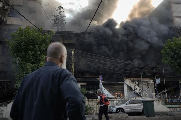 Flames and smoke rise from a destroyed building at the site of an Israeli airstrike in Dahiyeh, Beirut. - Sputnik International