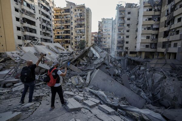 Journalists document damaged buildings at the site of an Israeli airstrike in Dahiyeh, Beirut. - Sputnik International