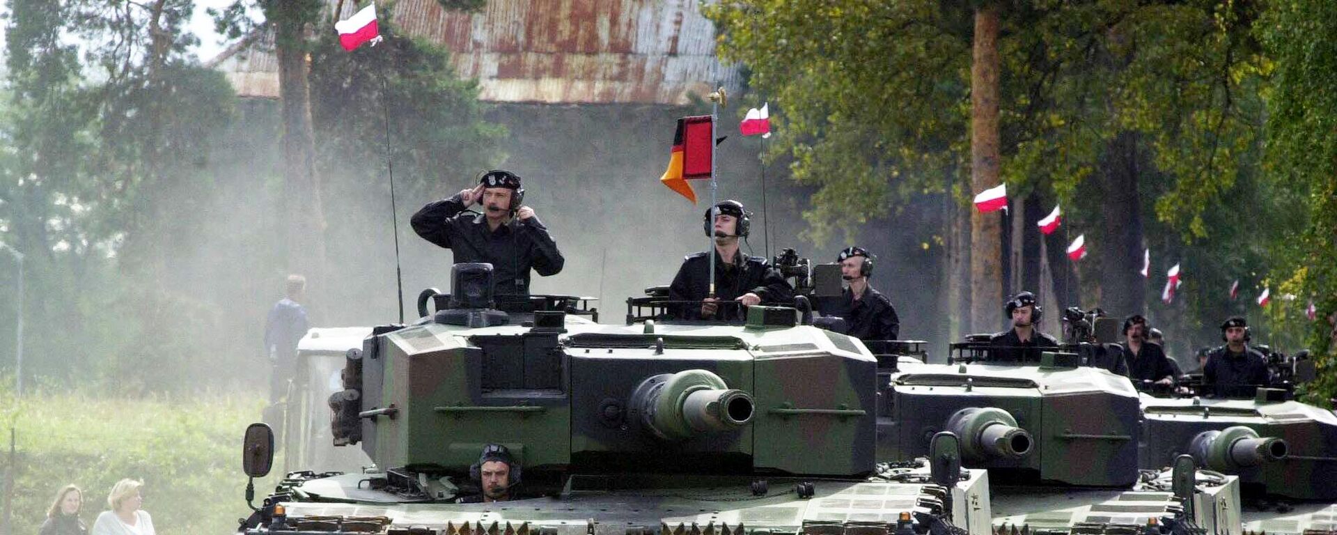 Polish soldiers parade through the streets of Swietoszow, in southwestern Poland in their Leopard tanks that they received Monday, Sept. 16, 2002  from the German Bundeswehr in a deal that is to help Poland's army upgrade to NATO requirements.  - Sputnik International, 1920, 09.10.2024