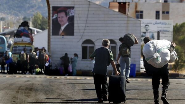 Syrians who fled the war in Lebanon carry their belongings as they arrive at the Syrian border crossing point, in Jdeidet Yabous, Syria, Monday, Oct. 7, 2024. (AP Photo/Omar Sanadiki) - Sputnik International