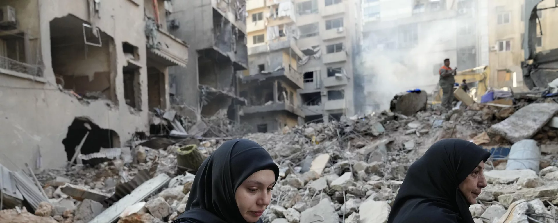 Lebanese women pass the destroyed buildings hit by an Israeli airstrike, in Beirut, Lebanon, Friday, Oct. 11, 2024.  - Sputnik International, 1920, 21.10.2024